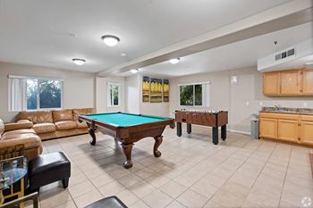 A game room with a pool table and couches